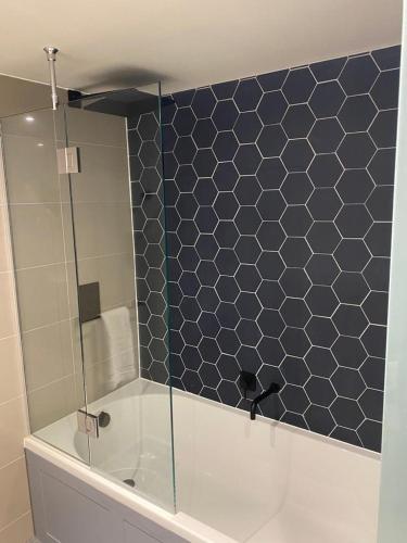 a bathroom with a shower with a toilet and a tiled wall at Wildes Inns in Chesterfield