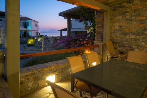 a table and chairs on a patio with a view of the ocean at Villa Ambrosia, beach house, Platanidia, Pelion in Platanidia