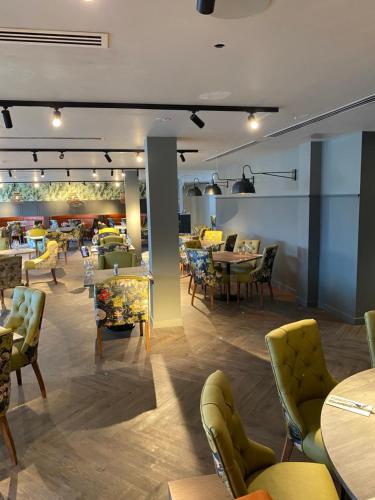 a restaurant with tables and chairs in a room at Wildes Inns in Chesterfield