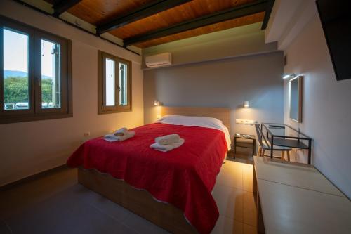 a bedroom with a red bed with two towels on it at Villa Ambrosia, beach house, Platanidia, Pelion in Platanidia