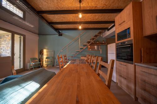a long wooden table in a kitchen with a staircase at Villa Ambrosia, beach house, Platanidia, Pelion in Platanidia