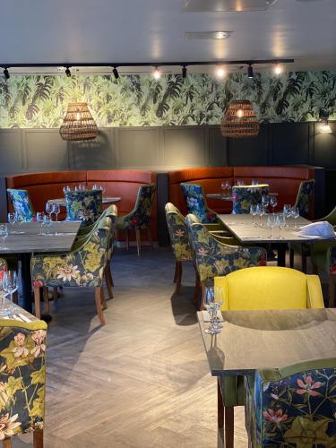a dining room with tables and chairs and lights at Wildes Inns in Chesterfield