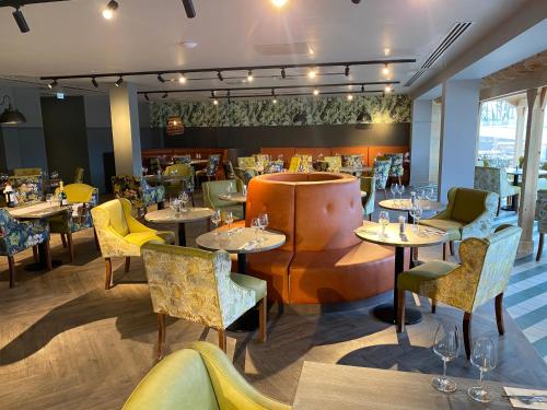 a restaurant with tables and chairs and a bar at Wildes Inns in Chesterfield
