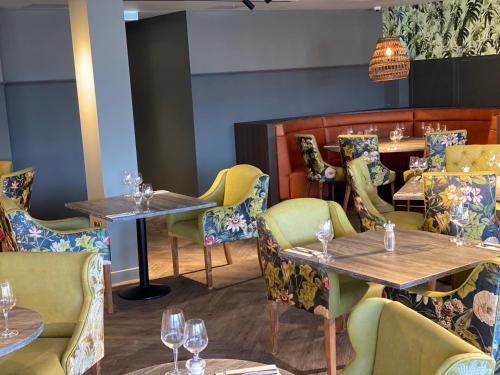 a restaurant with tables and chairs with wine glasses at Wildes Inns in Chesterfield