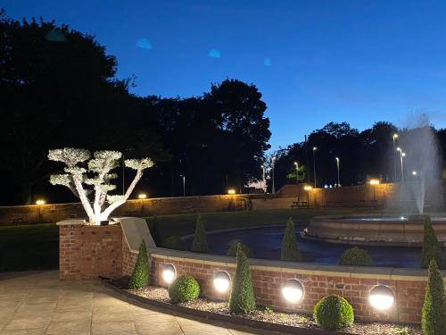 a fountain in a park at night with lights at Wildes Inns in Chesterfield