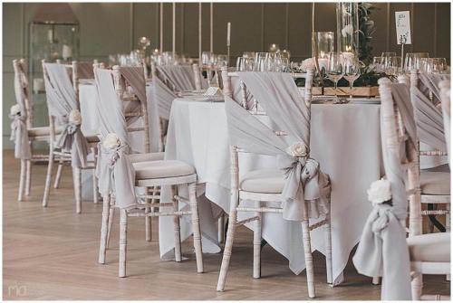 a row of tables and chairs with white tablecloths at Wildes Inns in Chesterfield