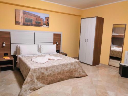 a bedroom with a large bed with two towels on it at Fratelli Clemente Spa and Hotel in Castelvetrano Selinunte
