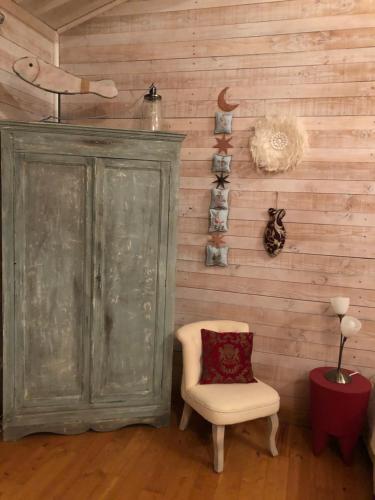 Cette chambre dispose d'une chaise et d'un mur en bois. dans l'établissement La maison bleue, à LʼIsle-sur-la-Sorgue