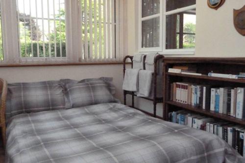 ein Schlafzimmer mit einem Bett und einem Bücherregal in der Unterkunft Willow Cottage in North Lydbury