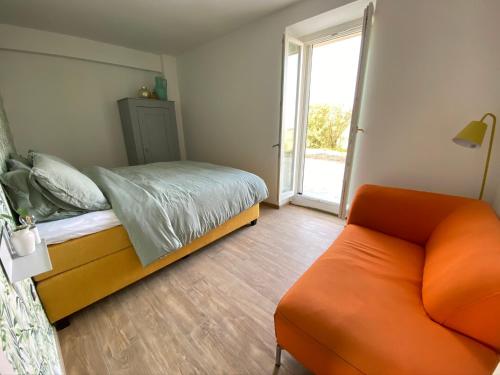 a bedroom with a bed and a couch and a window at Allegro Holiday in Nizza Monferrato