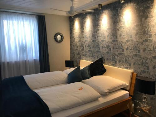 a bedroom with two beds and a wall with a clock at Hotel Garni Maaß in Braubach