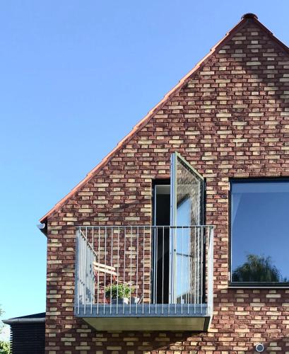 a brick house with a balcony with a window at Villa Stjerneklar in Copenhagen