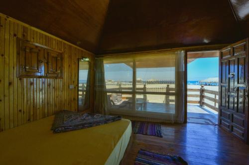 a bedroom with a bed and a view of the ocean at Ananda Beach Camp in Nuweiba‘ el Muzeinah