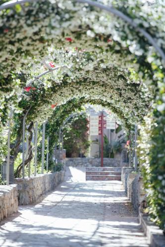 an archway with plants and flowers on it at Akti Taygetos - Conference Resort in Kalamata