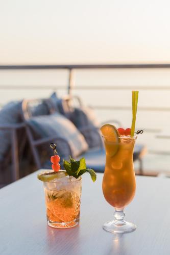 a table with two cocktails and a vase on it at Akti Taygetos - Conference Resort in Kalamata