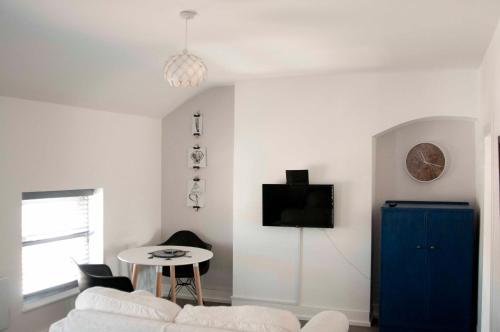 a living room with a white couch and a table at Chandos Apartments in Broadstairs