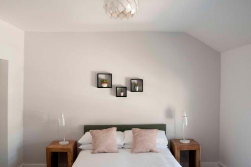 a bedroom with a bed with three pictures on the wall at Chandos Apartments in Broadstairs