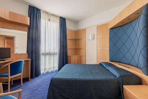 a hotel room with a bed and a desk at Hotel Ristorante Al Mulino by LVG Hotel Collection in Alessandria