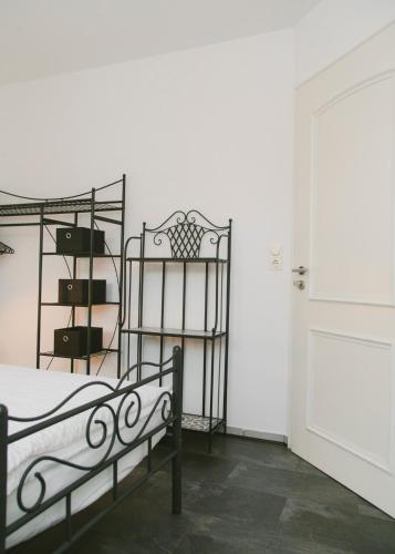 a white room with a bed and a door at Gästehaus Vigliarolo gewerblich Jedes Zimmer eigenes Bad Gemeinschaftsküche in Elmshorn