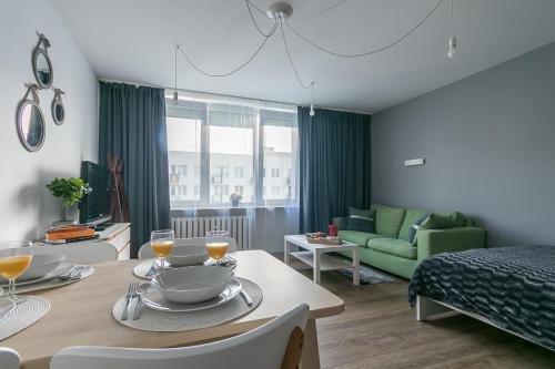 - un salon avec une table et un canapé vert dans l'établissement Murano Art Home, à Varsovie