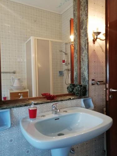 a bathroom with a white sink and a mirror at Appartamento d'Artista in Piazza Armerina
