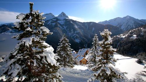 a snow covered mountain with trees and a cabin at SOWELL RESIDENCES Pra Loup in Pra-Loup