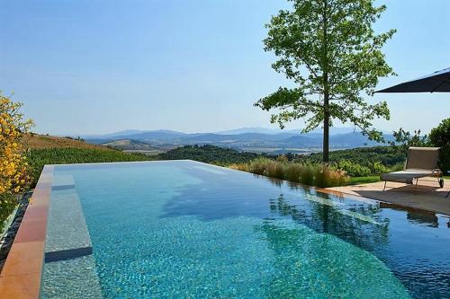 una piscina con tavolo, sedia e albero di Sequerciani a Tatti