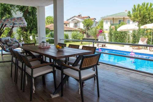 a dining room with a table and chairs next to a swimming pool at CRESCENT TWINS- BLUE VİLLA in Dalyan