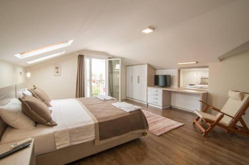 a large bedroom with a large bed and a chair at CRESCENT TWINS- BLUE VİLLA in Dalyan