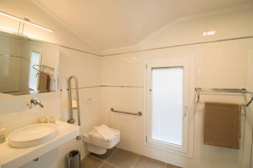 a bathroom with a sink and a toilet and a window at CRESCENT TWINS- BLUE VİLLA in Dalyan