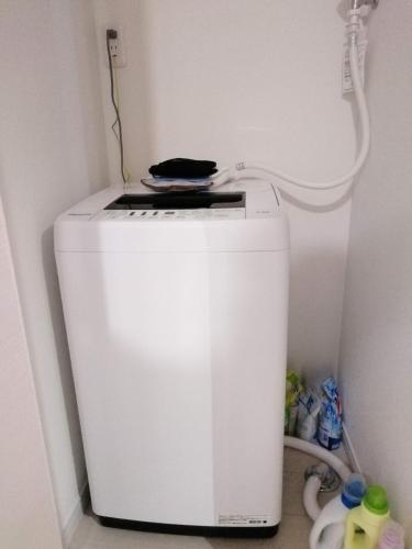 a small white refrigerator in a corner of a room at クレアゲハウス新百合ケ丘 in Kawasaki