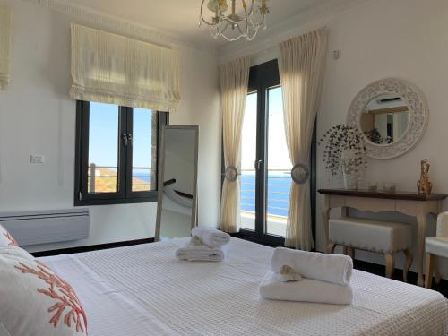 a white bedroom with a bed with towels on it at Villa Muse in Agios Nikolaos