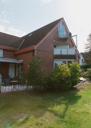 a red brick house with a balcony and a patio at Gästehaus Vigliarolo gewerblich Jedes Zimmer eigenes Bad Gemeinschaftsküche in Elmshorn