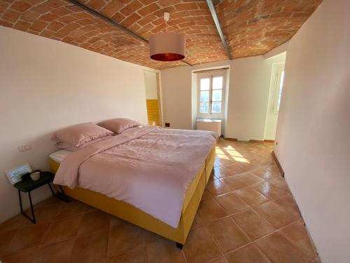a bedroom with a bed with pink pillows on it at Allegro Holiday in Nizza Monferrato