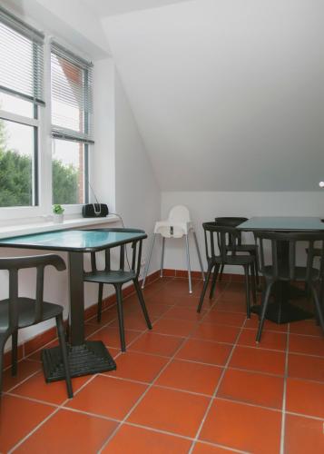 an empty room with tables and chairs on a orange floor at Gästehaus Vigliarolo gewerblich Jedes Zimmer eigenes Bad Gemeinschaftsküche in Elmshorn