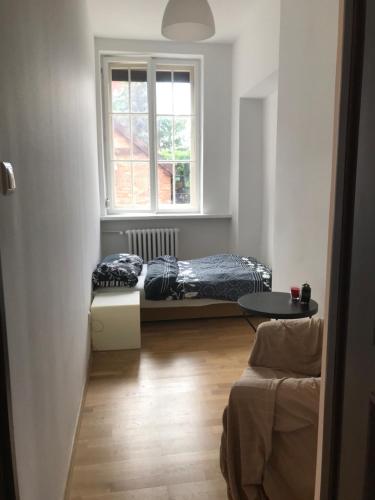 a living room with two beds and a window at Przytulny Apartament w samym centrum Gdańska in Gdańsk