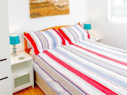 ダートマスにあるHi-De-Hi Chalet 111のベッド(赤白、青色の縞模様の毛布付)