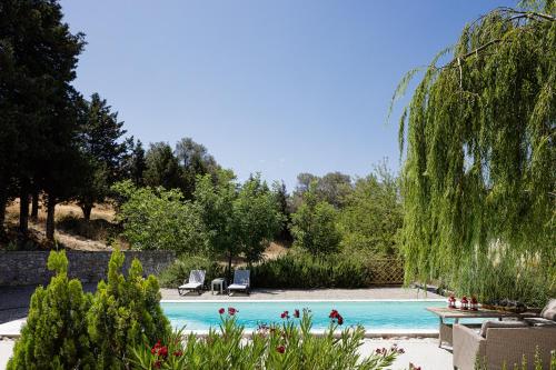 a swimming pool in a yard with trees at Tessera Villa, a Serene Escape in Nature with Pool, By ThinkVilla in Spílion
