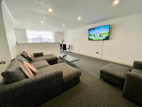a living room with two couches and a flat screen tv at Fabrik Apartments - Harrowside by Blackpool Service Apartements in Blackpool