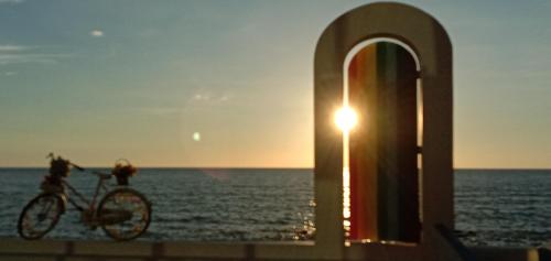 a bike parked in front of the ocean at sunset at 爱上海蓝蓝屋民宿 Blue Ocean Station in Penampang