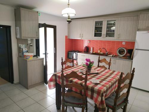 une cuisine avec une table et des chaises et une cuisine avec du carrelage rouge dans l'établissement Theanos House, à Pigi