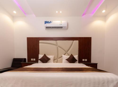 a bedroom with a large bed with a white bedspread at مكارم الورود للشقق المخدومة in Taif