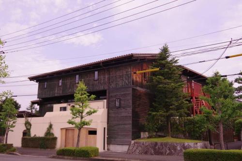 a house with a wooden facade on a street at Miyajima Breeze in Hatsukaichi