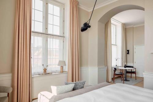 a bedroom with a bed and a chair and a window at Villa Copenhagen in Copenhagen