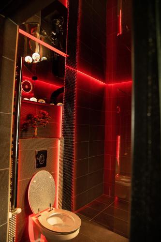 a bathroom with a toilet and a red light at Excentric Studio 2 in Braşov