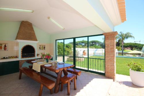 a dining room with a table and a fireplace at Villa Fonte Santa in Quarteira