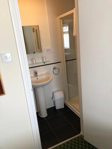 
a bathroom with a sink, toilet, and shower at Granby Hotel in Gravesend
