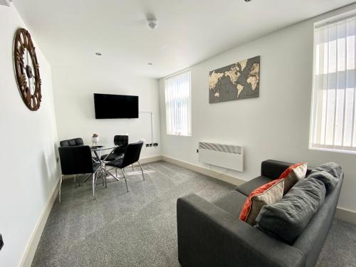 a living room with a couch and a table at Winter Gardens Service Apartments by Blackpool Service Apartments in Blackpool