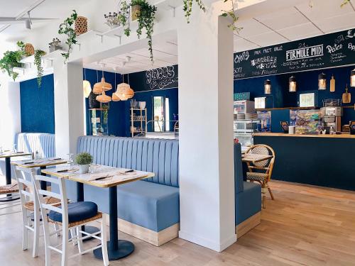 een restaurant met blauwe muren en een tafel en stoelen bij Hotel Le Provence - Restaurant Le Styx in La Palud sur Verdon