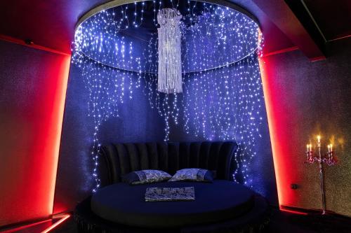 a room with a bed with lights and a chandelier at Excentric Studio 2 in Braşov